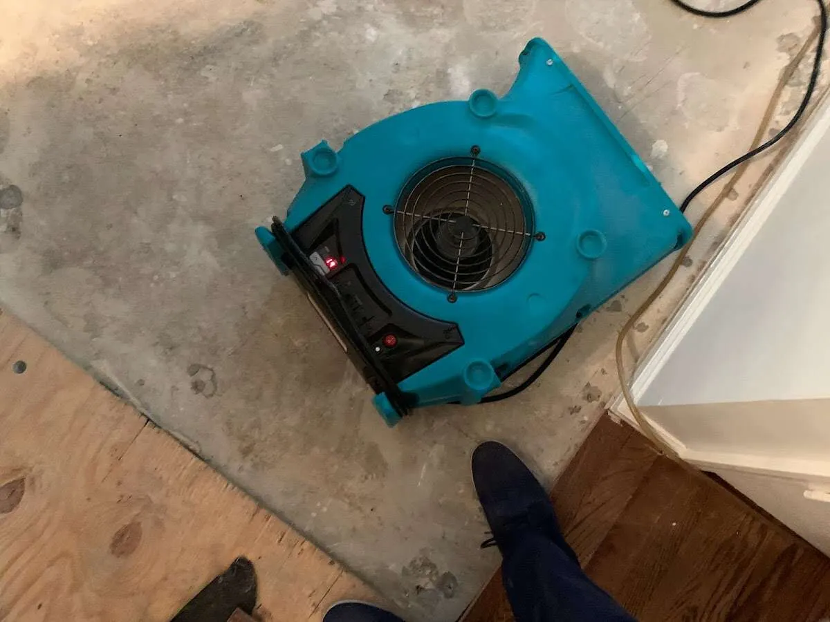 Air mover drying subfloor during Leak Detection & Repair in Manchester